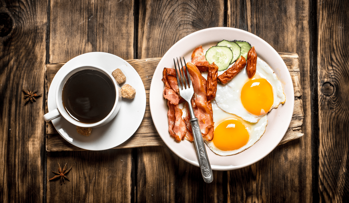 Delicious morning meal with eggs, bacon, fresh cucumbers, and a hot cup of coffee for a balanced breakfast.